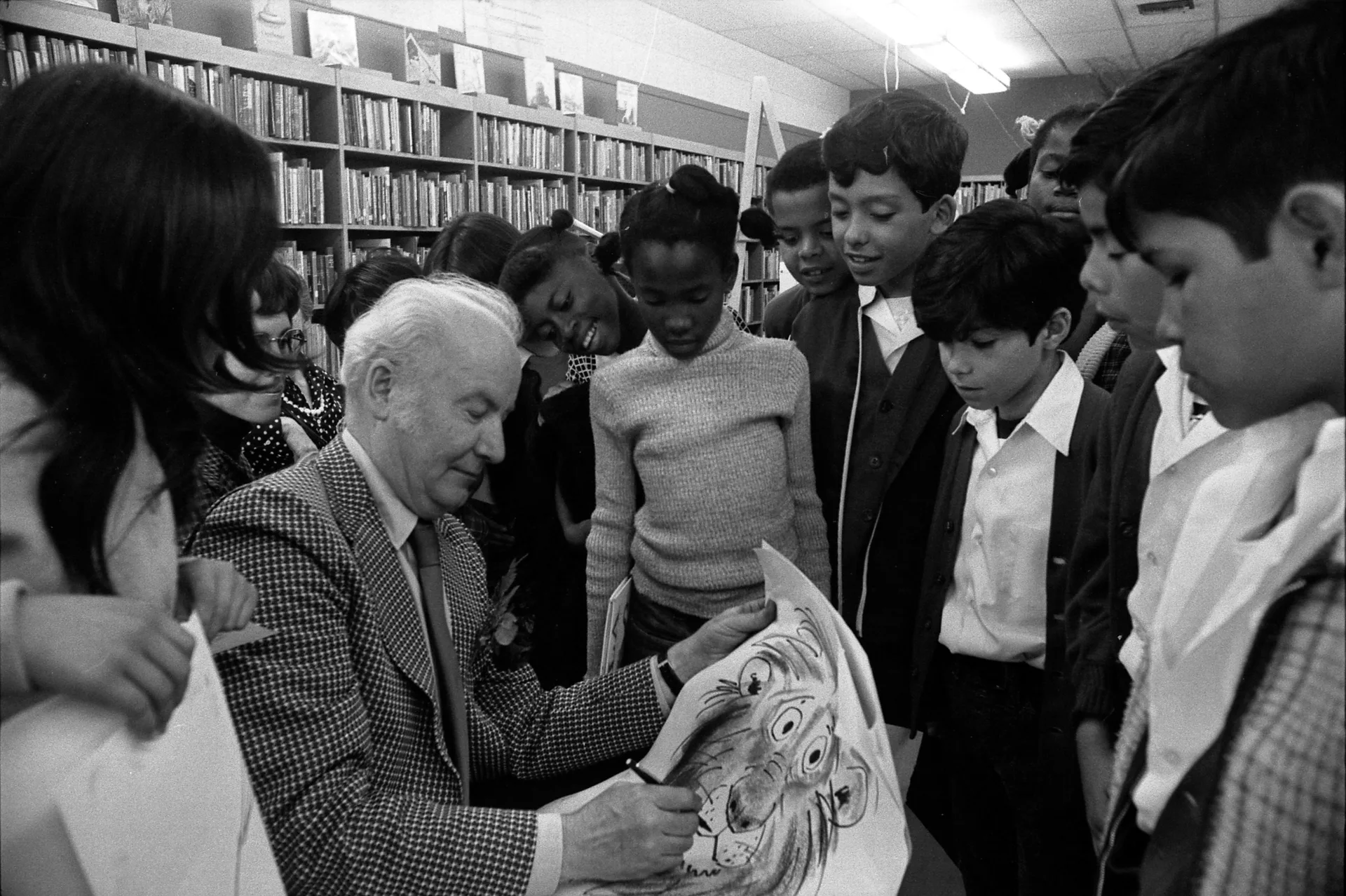 Bill Peet autographing a drawing of Hubert the Lion for a group of school children in Los Angeles